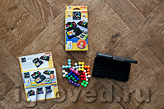 Компоненты настольной игры-головоломки IQ-Гений: коробка с двумя игровыми полями, книжка с правилами игры и заданиями, разные детали